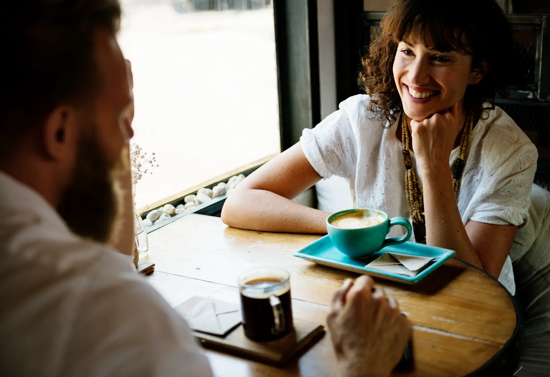 Duas pessoas conversando alegremente em um café