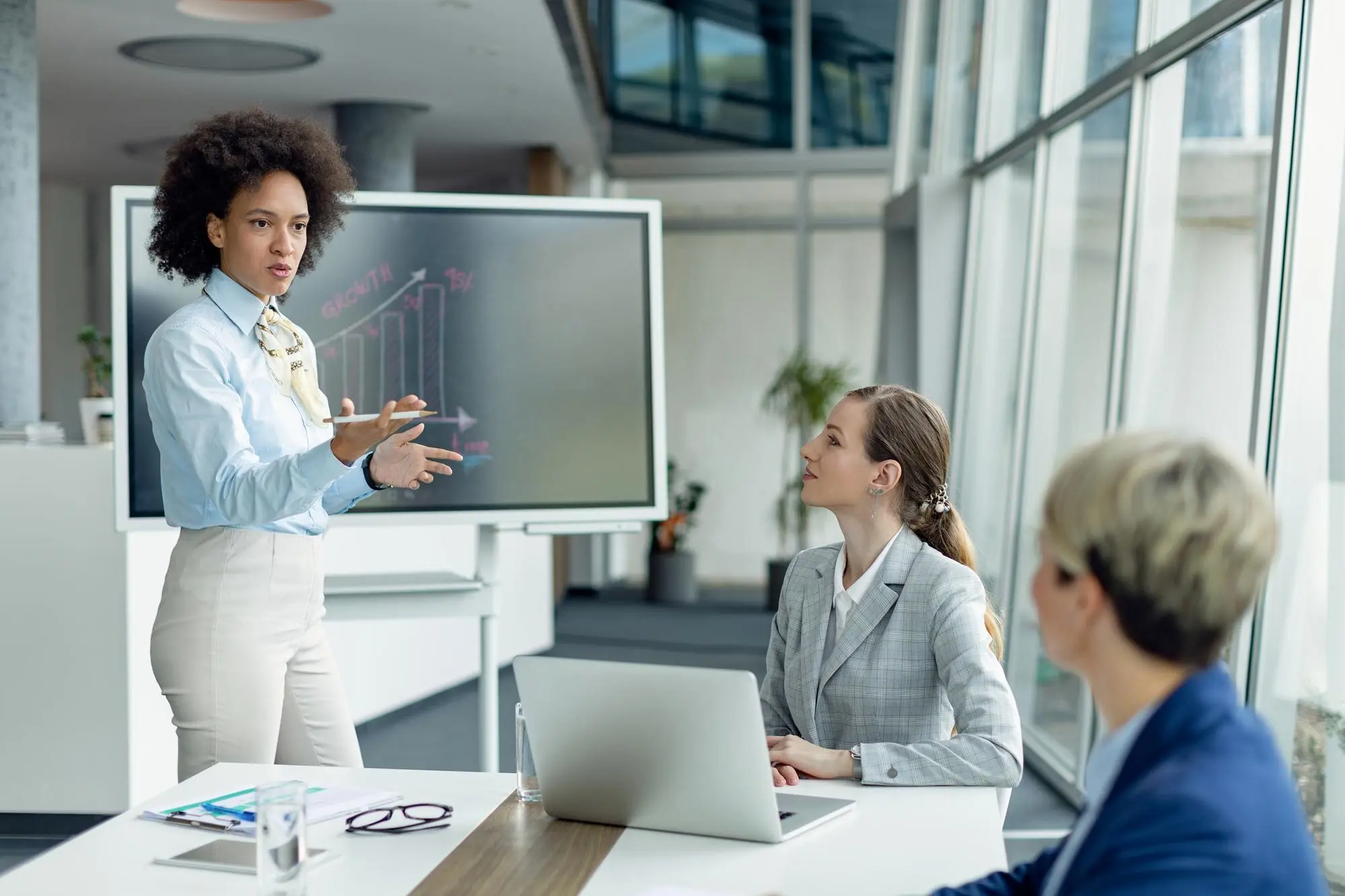 Profissionais em reunião de trabalho com apresentação visual